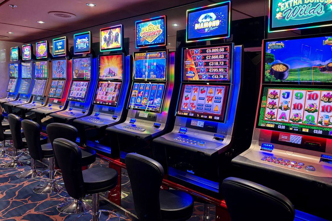 Barisan mesin slot penuh warna di lantai kasino